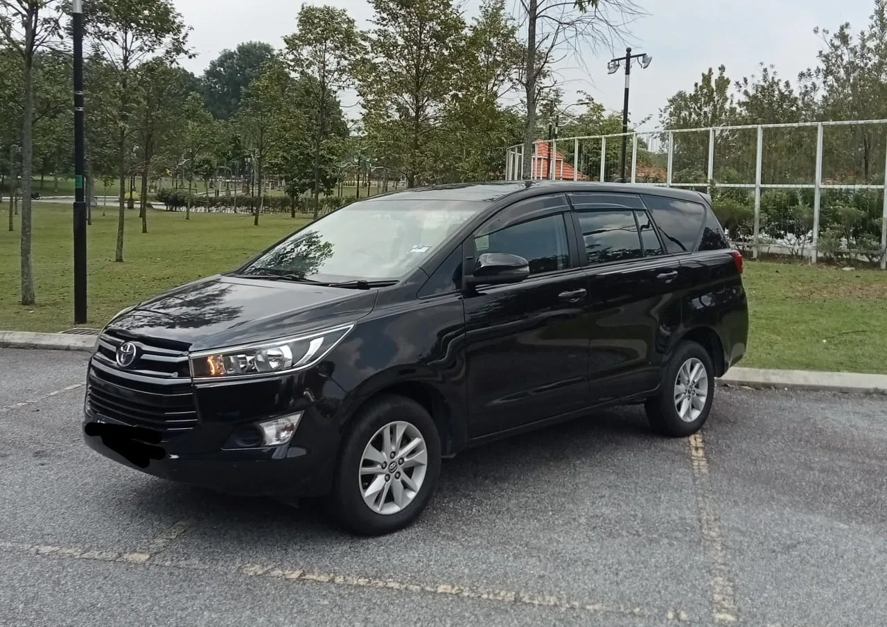 Black Toyota Innova at landscaped park entrance